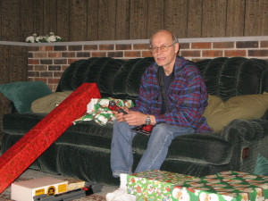 an elderly man showing his Christmas presents